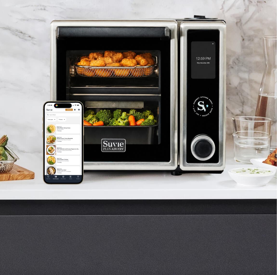 Suvie Kitchen Robot on a counter with cooked sides and the Suvie app